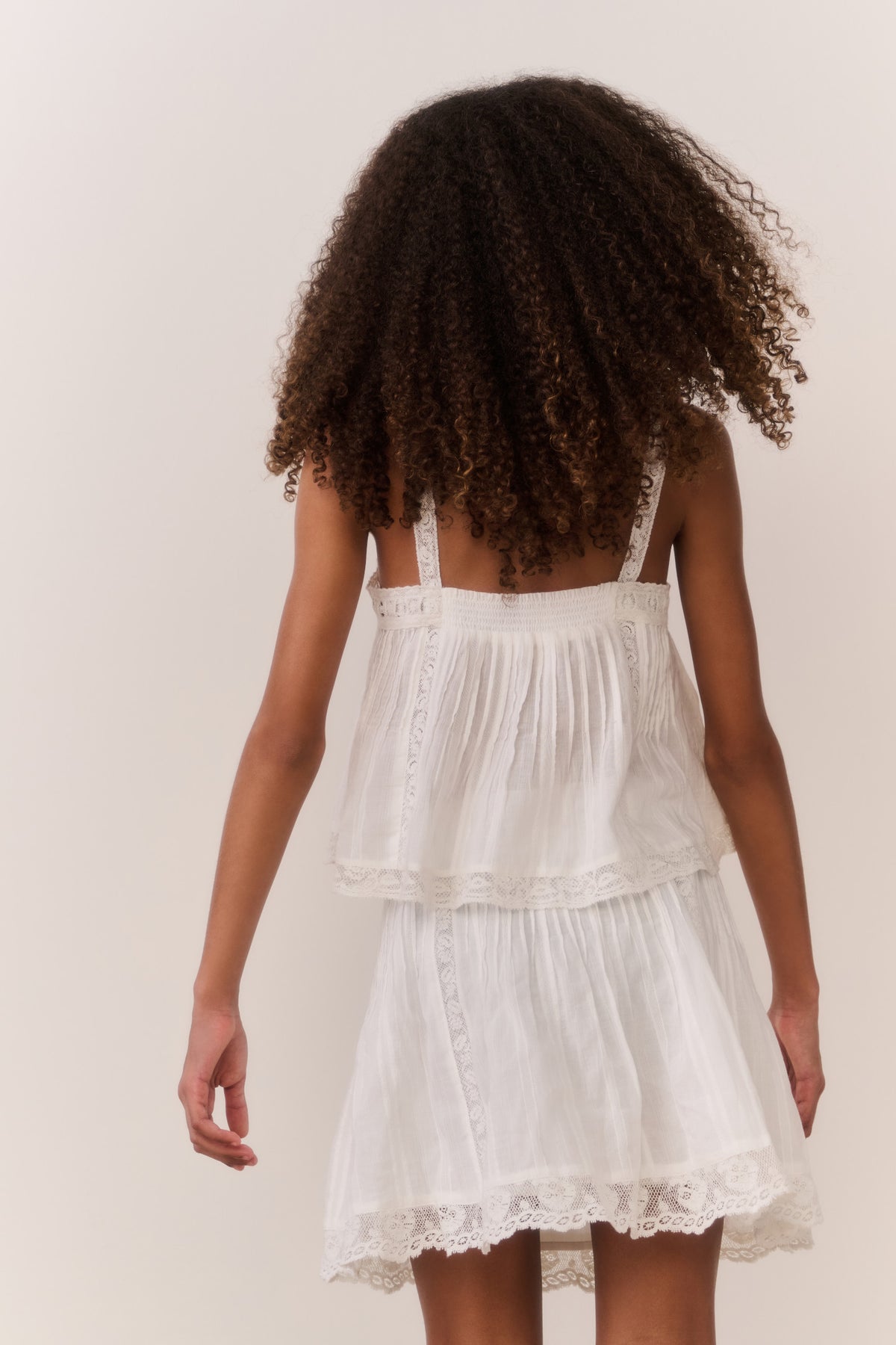 White cotton tween top with spaghetti straps, pleated back yoke, tiered ruffle hem
