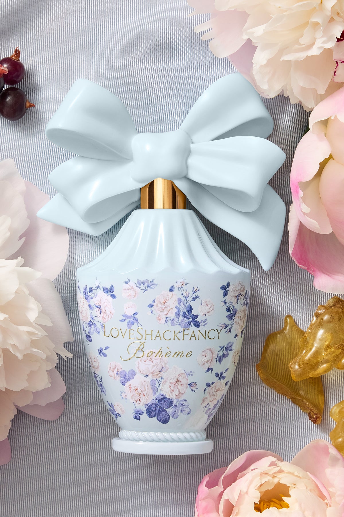 Light blue decorative perfume bottle with light blue bow and blue floral label