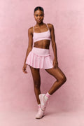 Pink sports bra with thin straps and geometric lattice pattern, full outfit view
