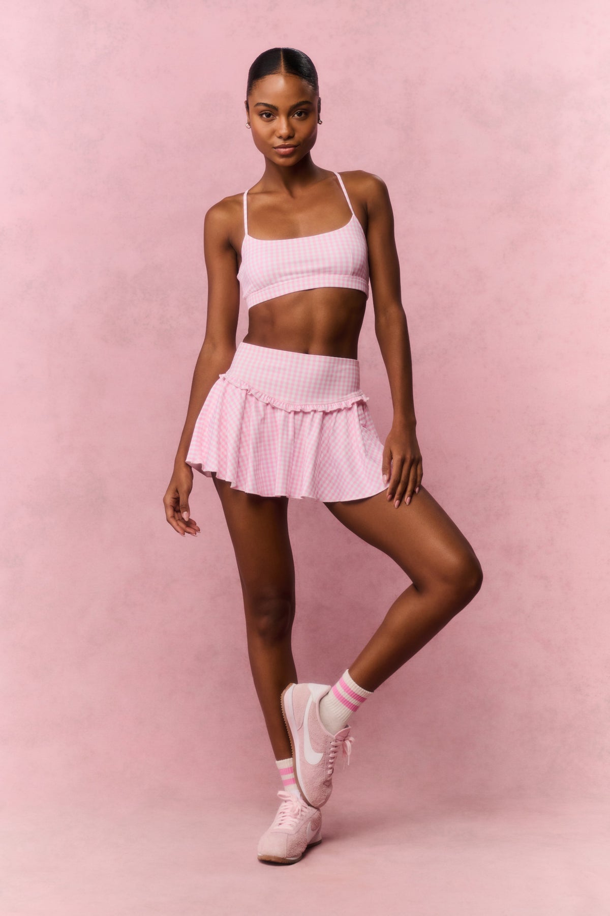 Pink sports bra with thin straps and geometric lattice pattern, full outfit view