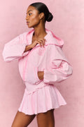 Pink gingham hooded zip windbreaker with swirl chest logo, long sleeves and gathered cuffs.