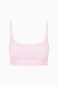 Light mauve bow-print sports bra with thin straps, flat lay