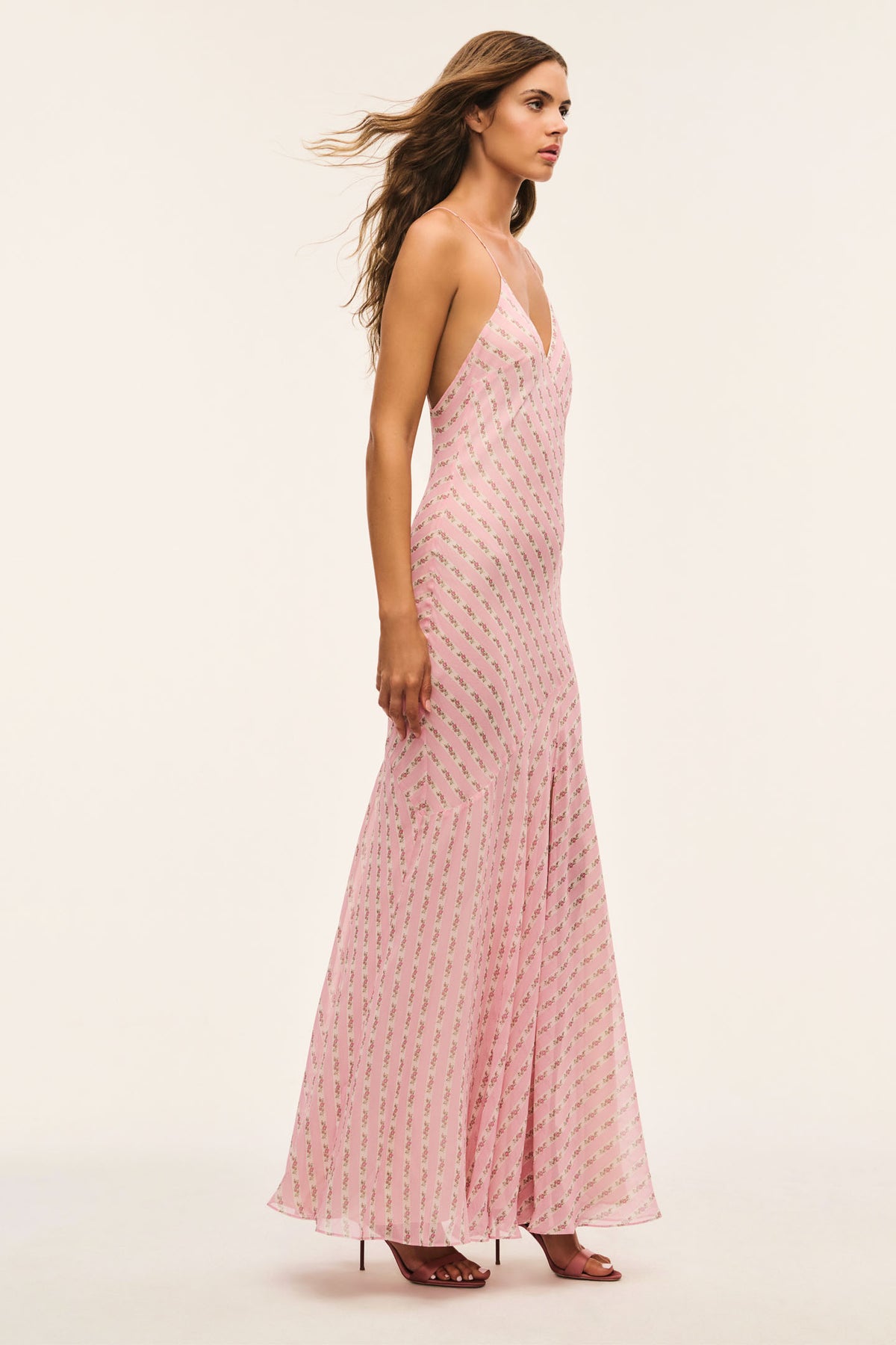 Light pink maxi dress angled side view with spaghetti straps, V-neck, and patterned fabric.