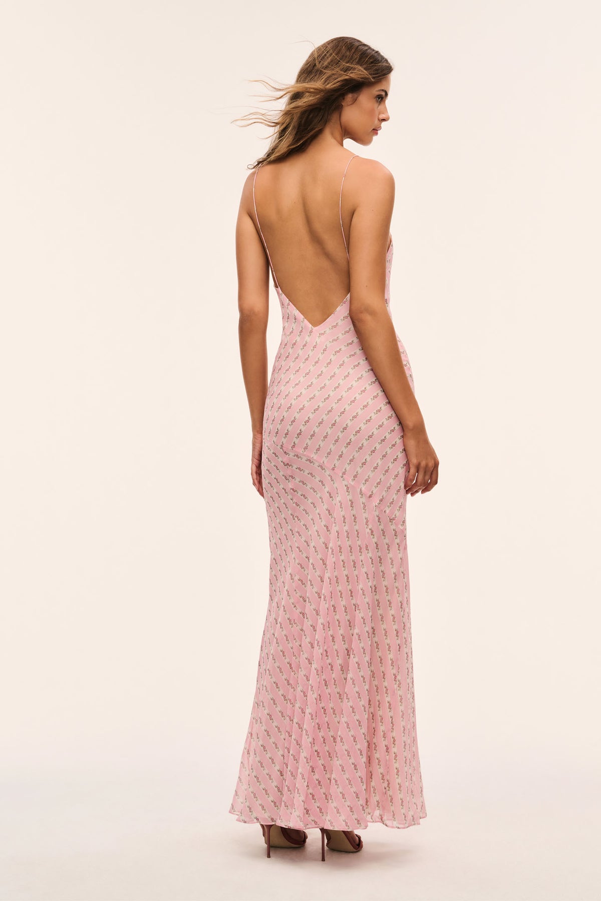 Light pink maxi dress back view with open back V shape, spaghetti straps, patterned fabric.