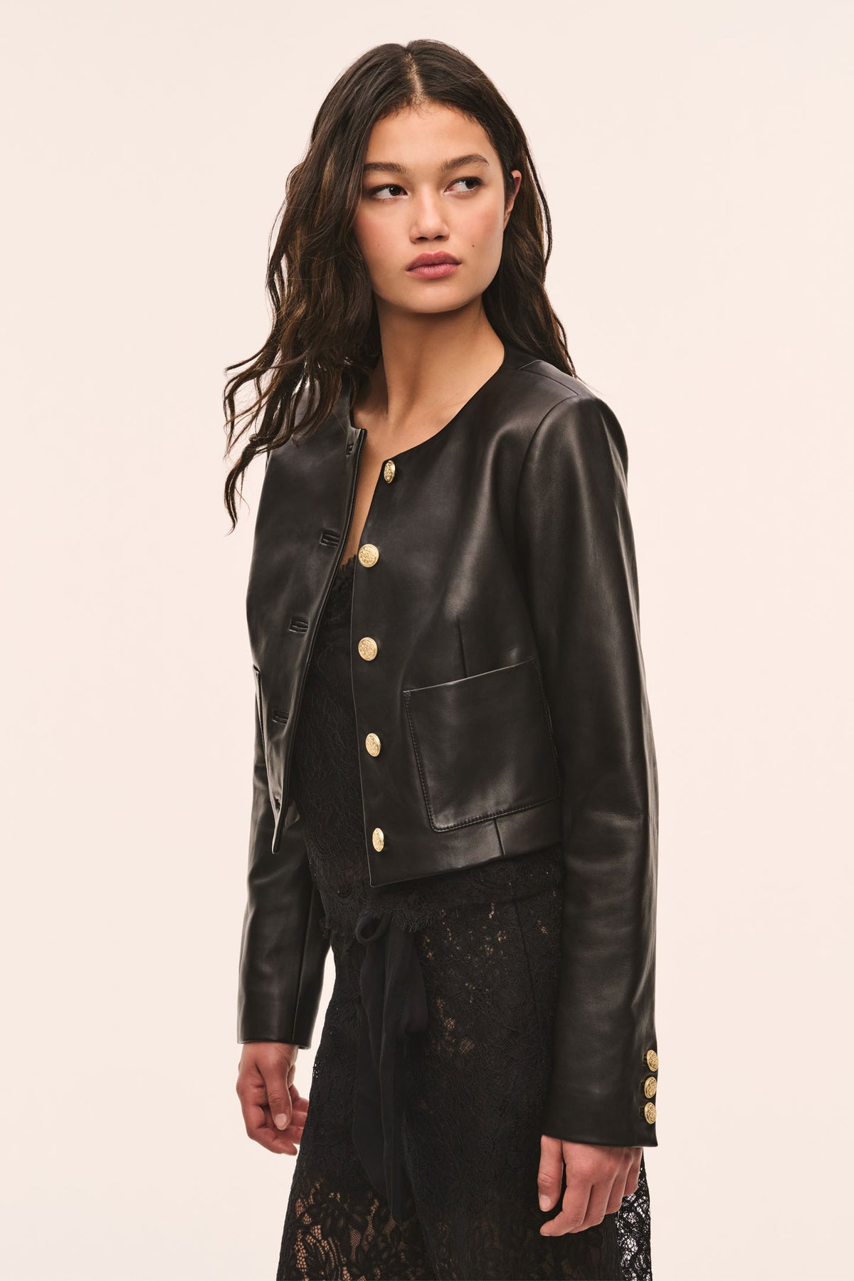 Black collarless leather jacket with gold snap buttons and two front pockets