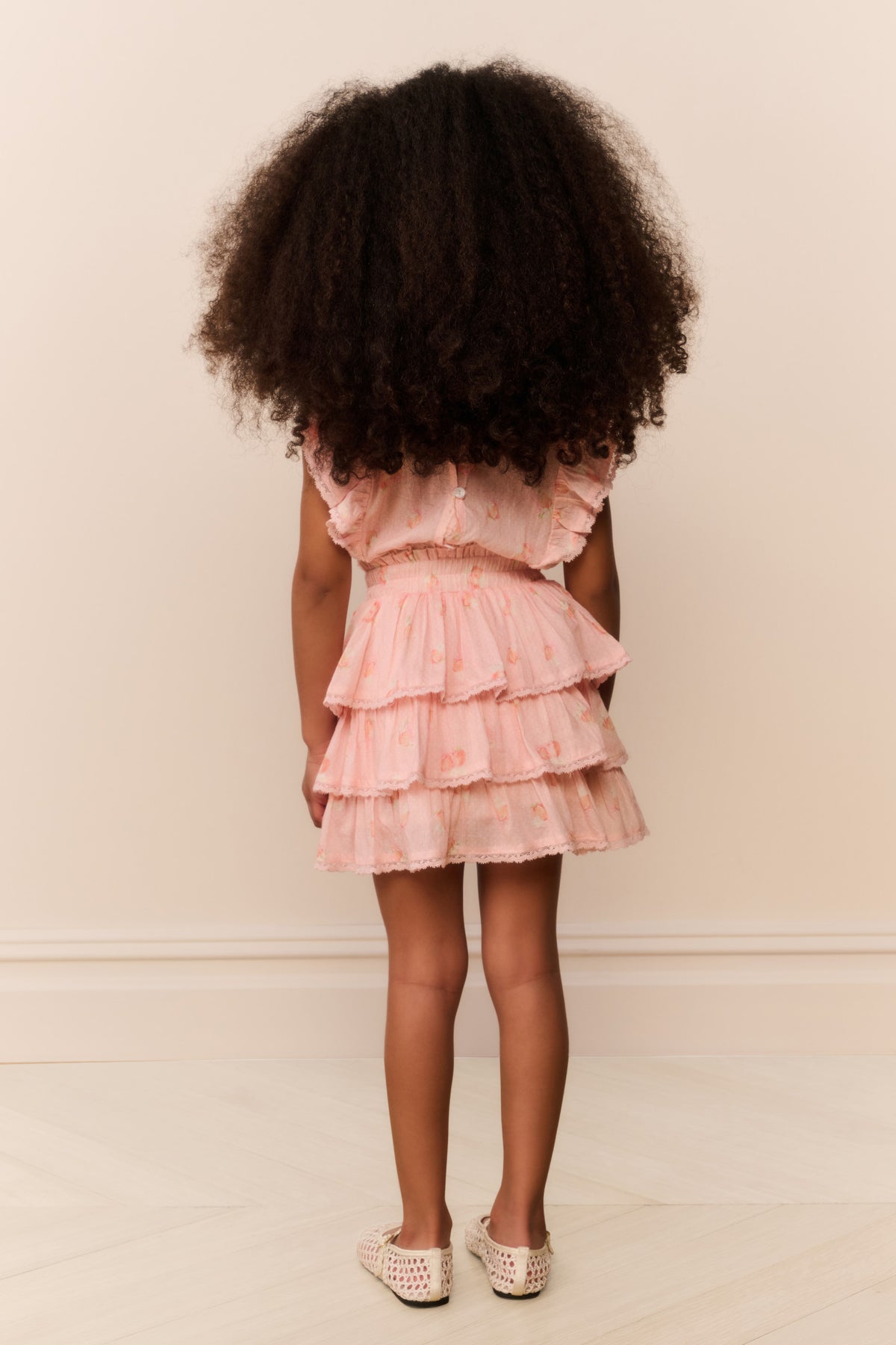 Girls peach tiered ruffle mini dress, back view with gathered bodice