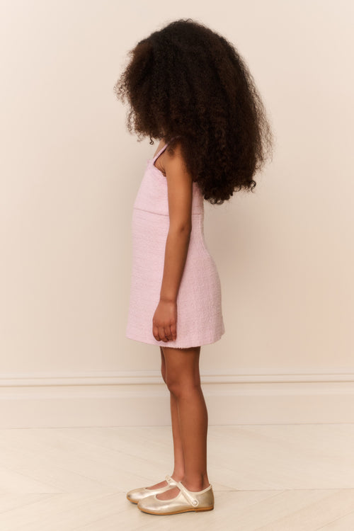 Pink sleeveless mini dress with lace neckline, back-facing side view