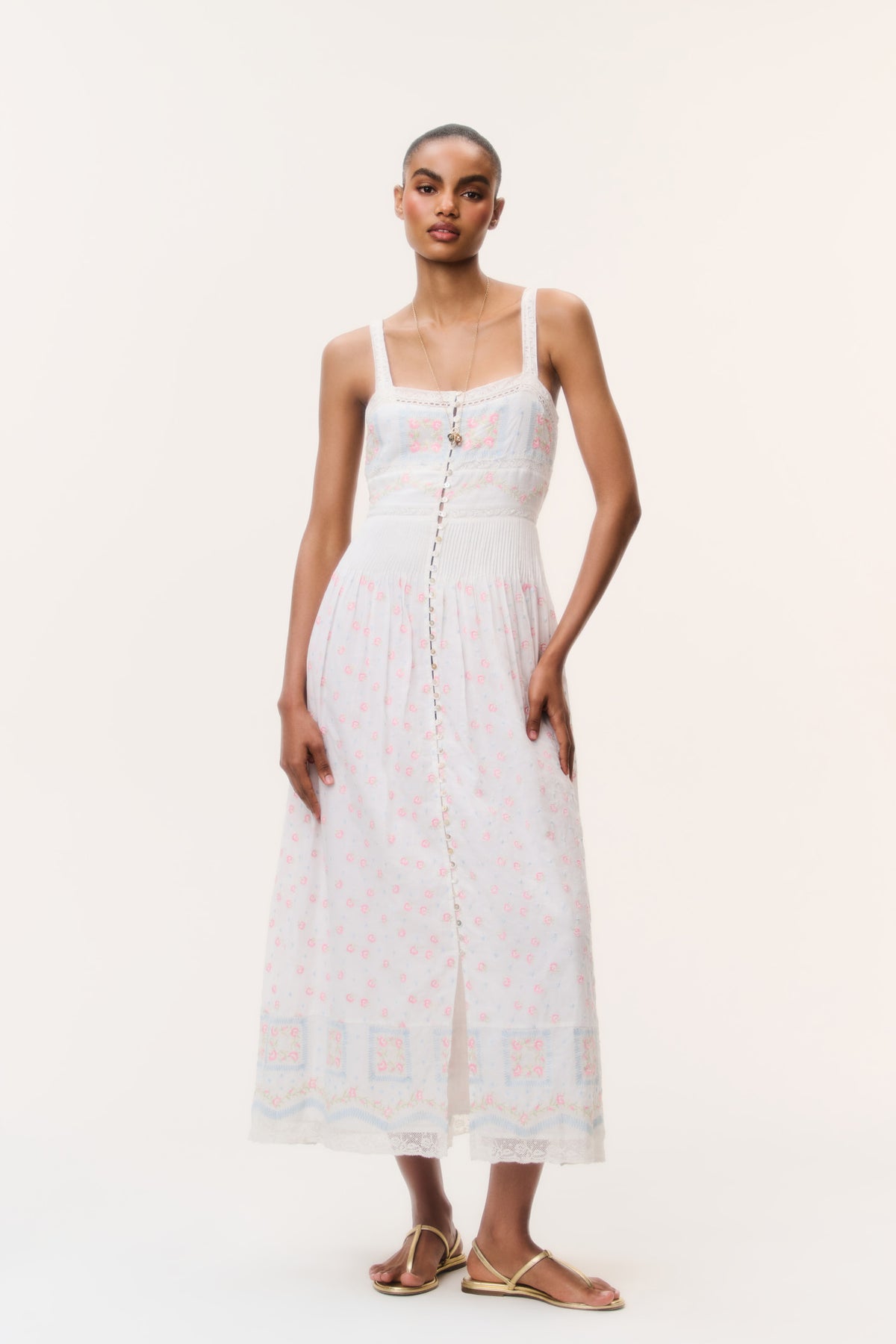 White cotton maxi dress with square neckline, pastel embroidery, and thin spaghetti straps