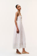 White cotton maxi dress side view with fitted bodice, pastel embroidered trim, thin straps