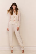 Cream lace-trimmed balloon pants with relaxed fit and elastic ruffle cuffs