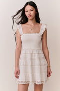 Front-view lace-trimmed cotton mini dress with scalloped lace trim and tiered layers