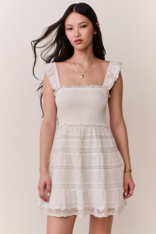 Front-view lace-trimmed cotton mini dress with scalloped lace trim and tiered layers