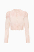 Light pink cropped jacket flat lay with button placket, puff sleeves, and lace-trim ruffle edges