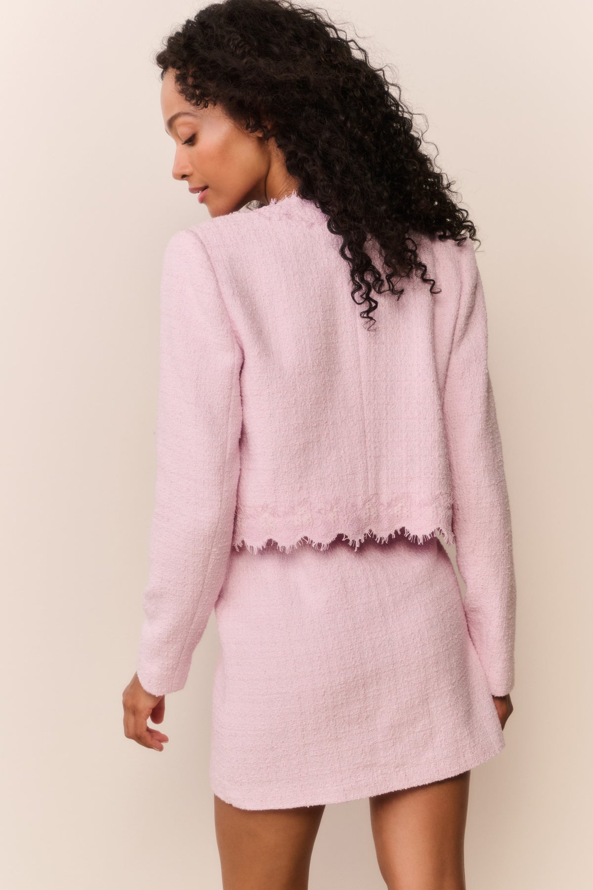 Pink lace-trimmed tweed jacket with scalloped hem detail, back view