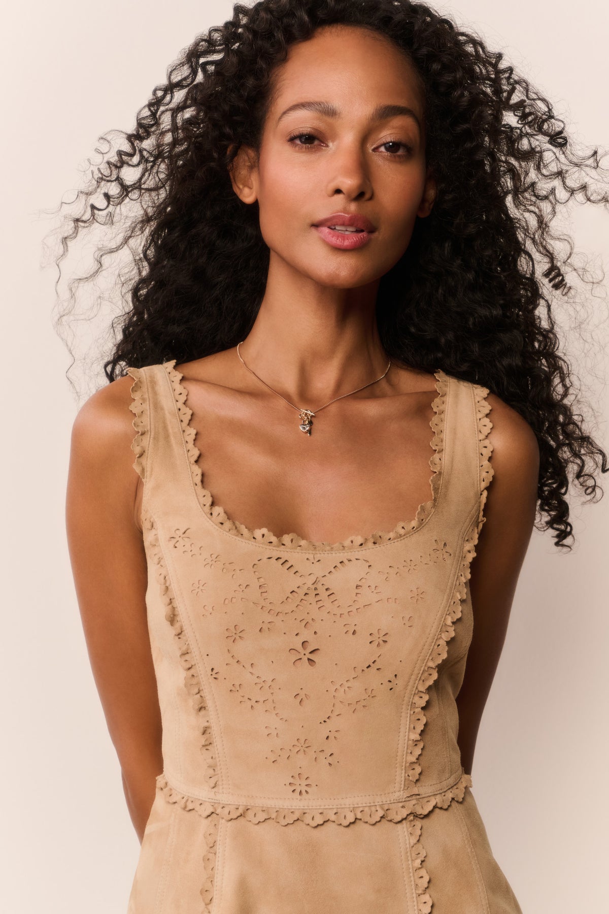 Tan suede eyelet mini dress with scalloped neckline and embroidered bodice