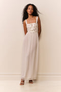 Cream sheer maxi dress with bow bodice, thin straps, and flowing skirt