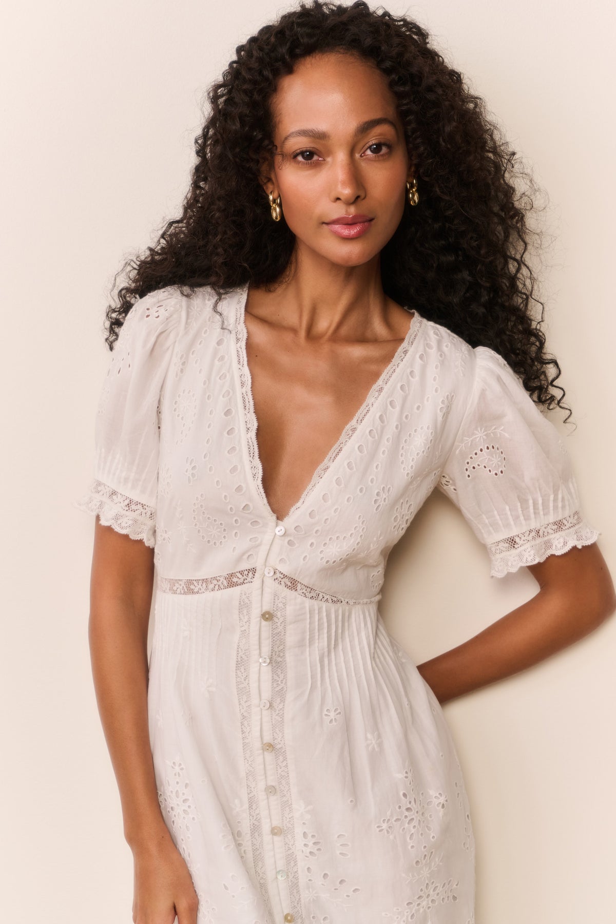White eyelet midi dress with V-neckline, puff sleeves, and button-front