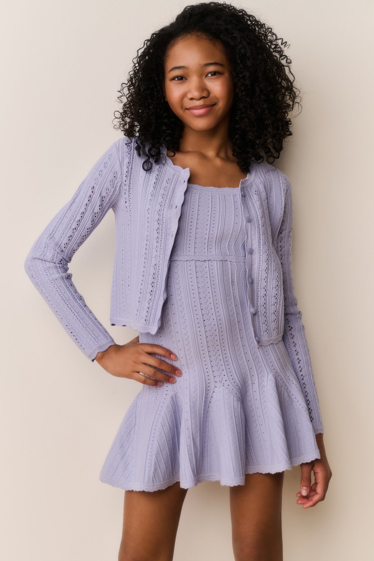 Lavender pointelle knit cardigan worn open, long sleeves, textured knit detail.