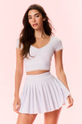 Light blue gingham skort on model, elastic waistband and pleated flared skirt