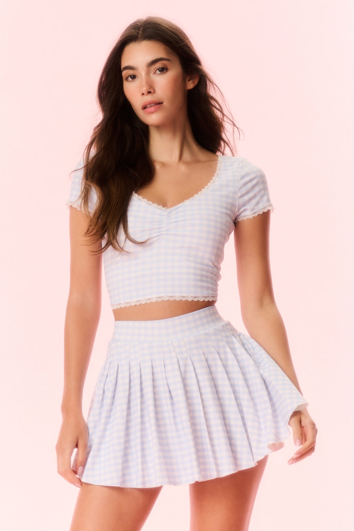 Light blue gingham skort on model, elastic waistband and pleated flared skirt