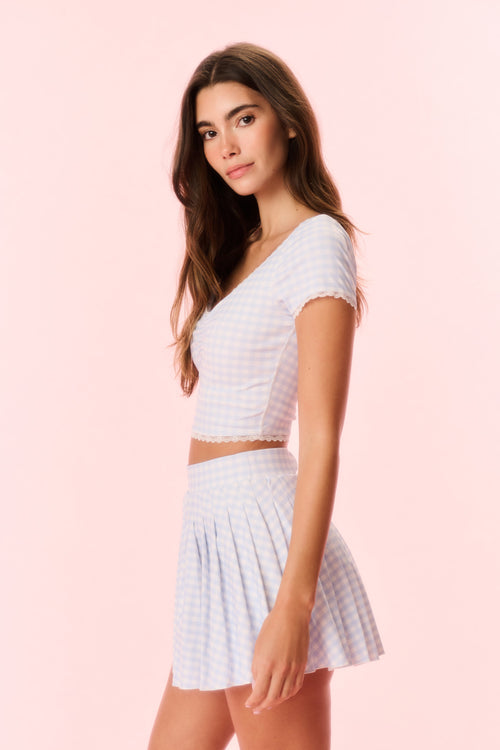 Light blue gingham skort on model, side view with pleated flared skirt