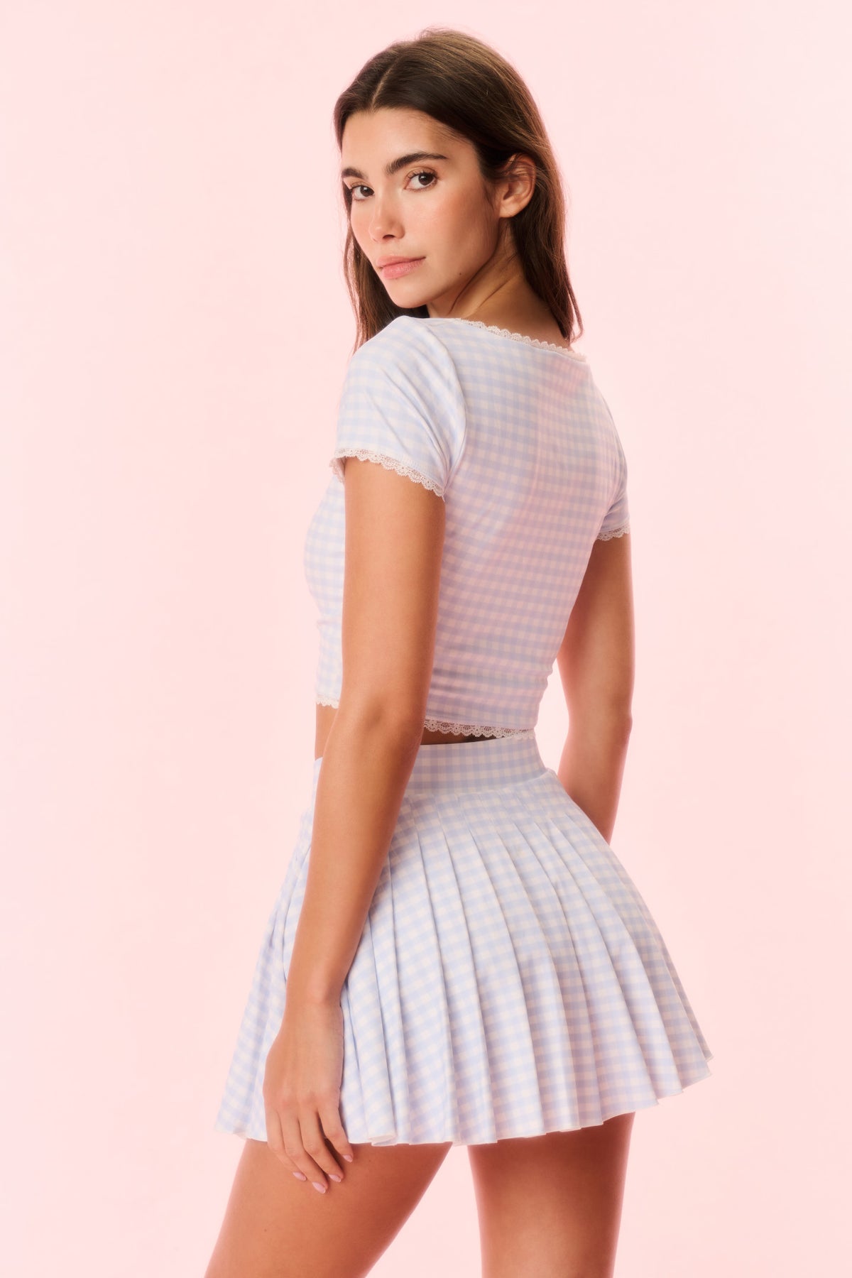Light blue gingham skort on model, angled view with pleated flared skirt