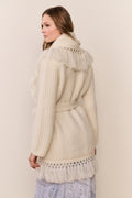 Ivory knit wrap cardigan with fringe shawl collar, back yoke, long sleeves.