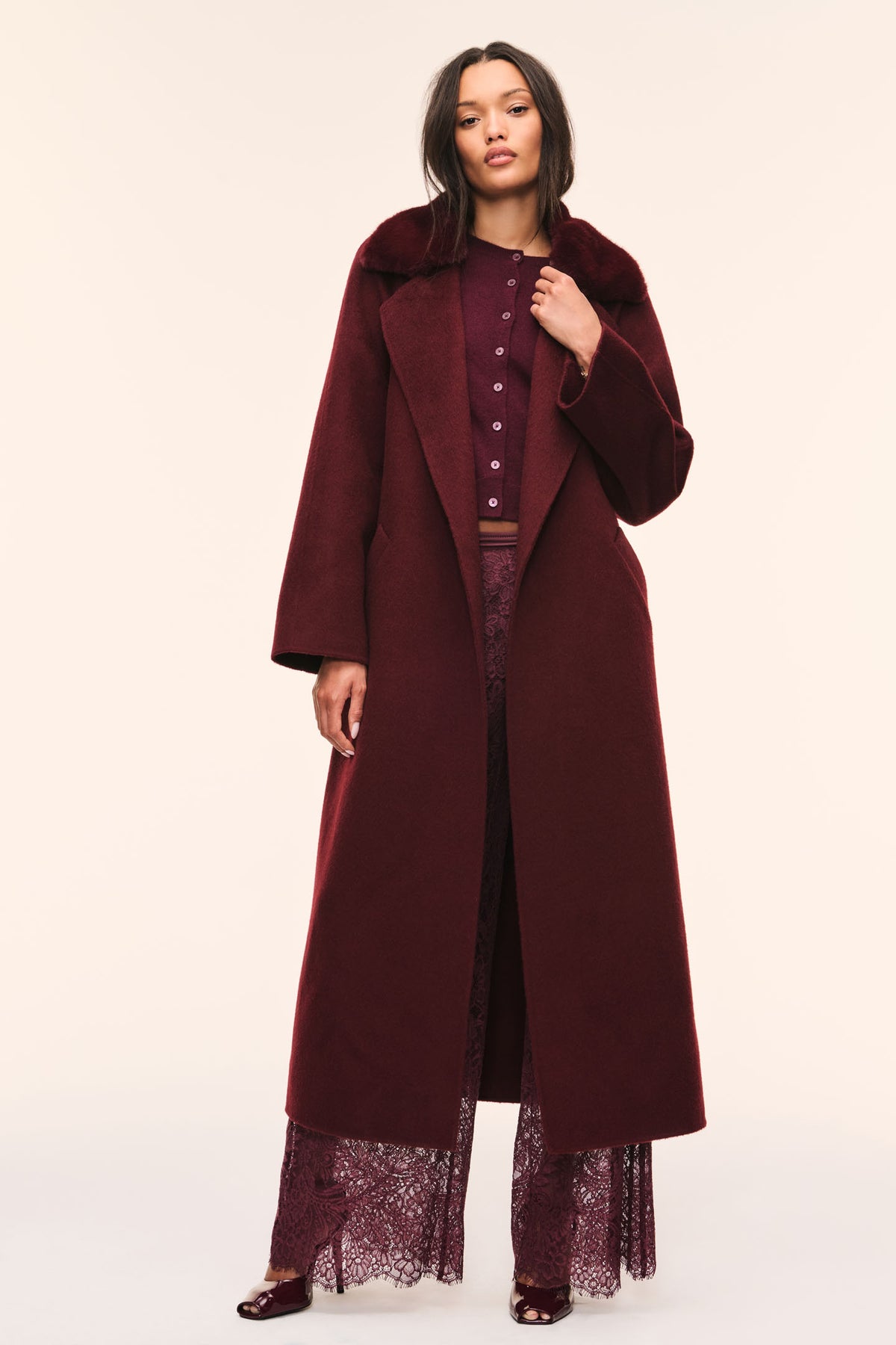 Long dark merlot wool coat with faux fur collar, button front, and waist tie belt.
