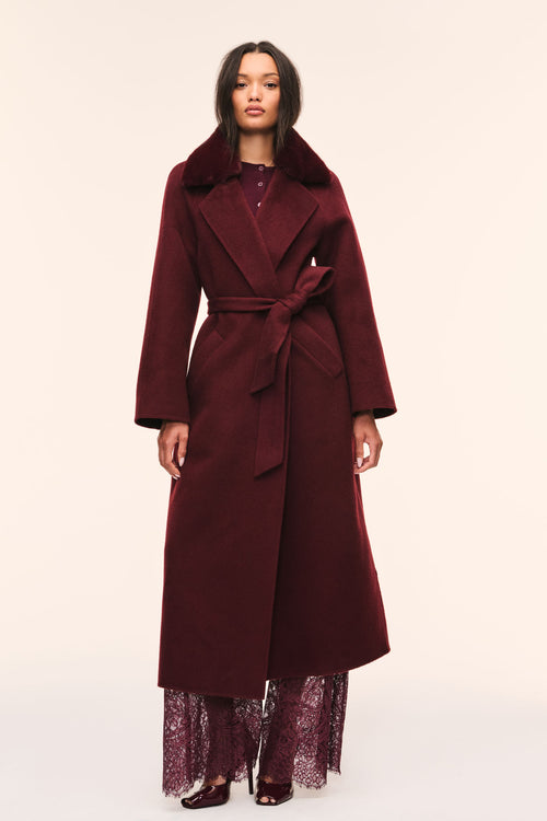Dark merlot long wool coat with faux fur collar and waist tie belt, worn with lace hem.