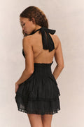 Black halter mini dress with tied open-back strap and tiered ruffle skirt