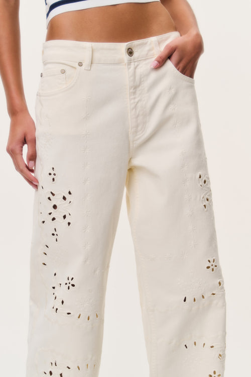 Ivory eyelet floral cutout wide-leg jeans close-up on front patchwork details