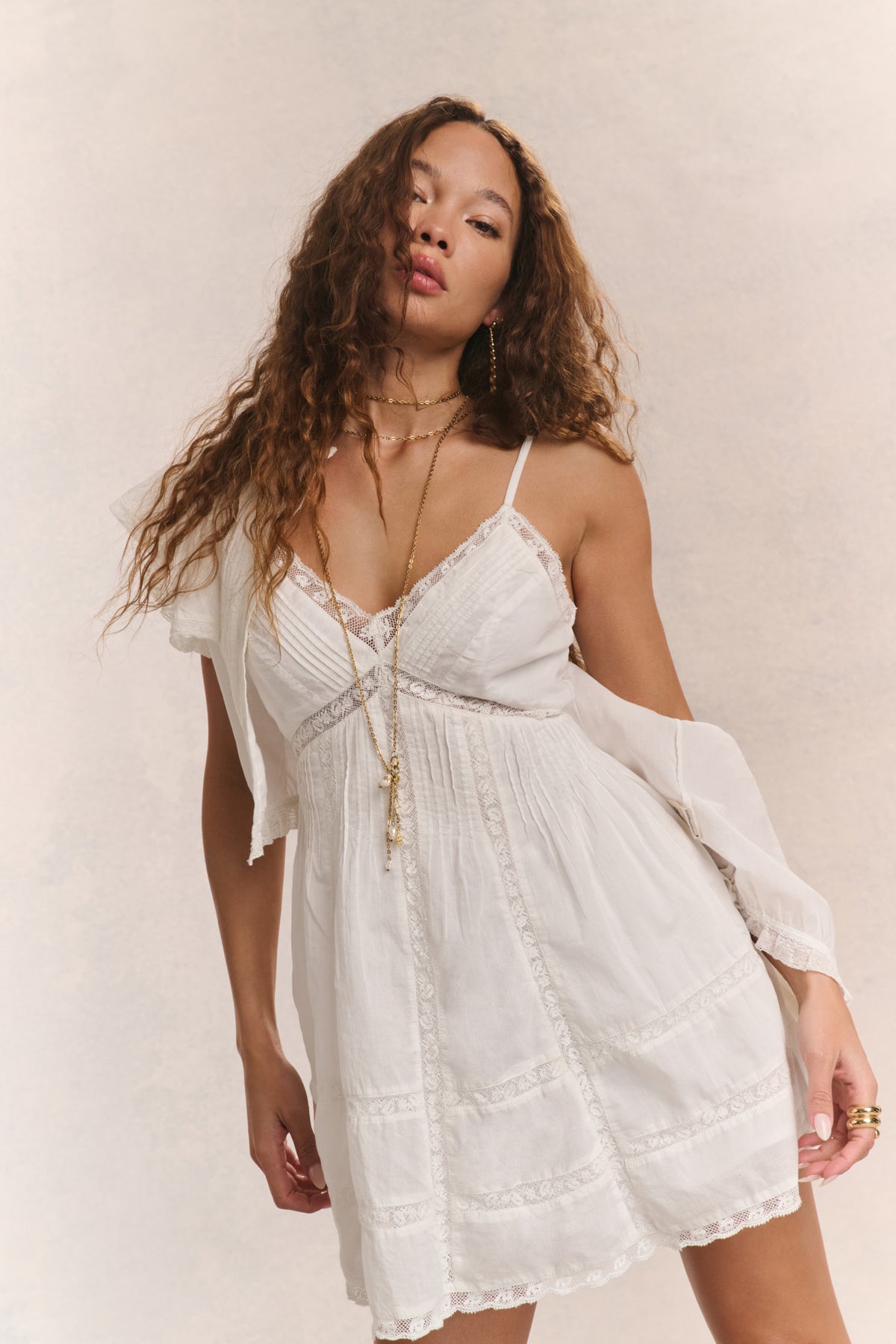 White cotton mini dress front view with lace V-neck and layered tiered skirt