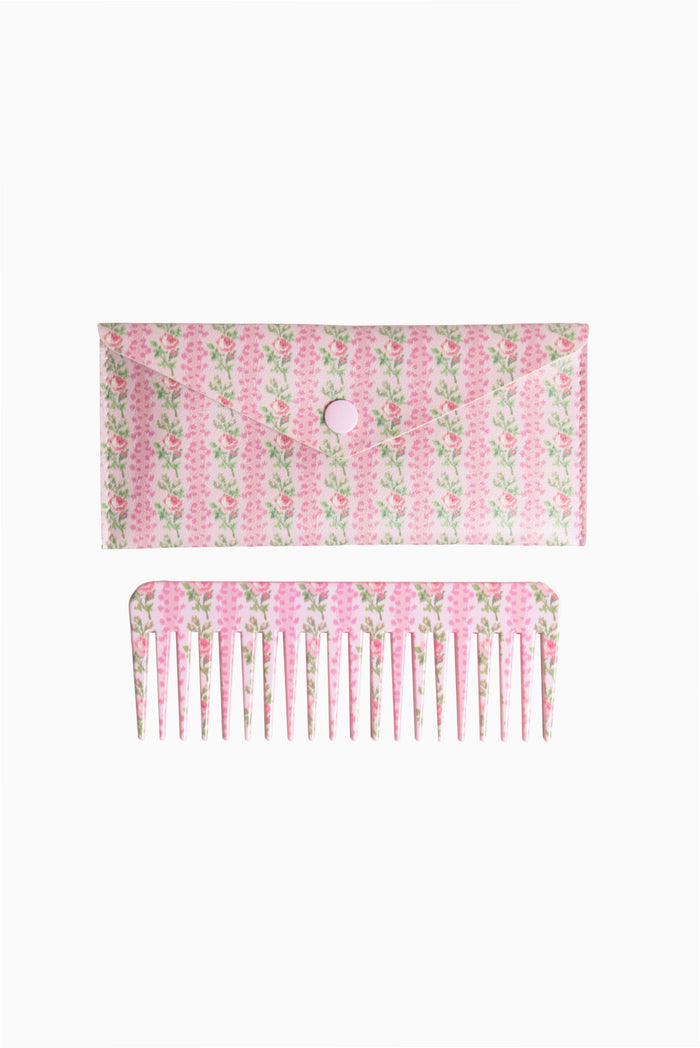 Pink and green floral hair comb with fine teeth, shown with backing card