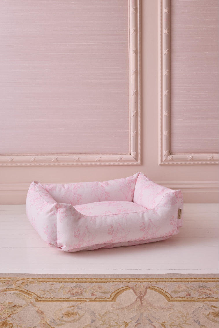 Pink printed dog bed with padded sides and low, open top