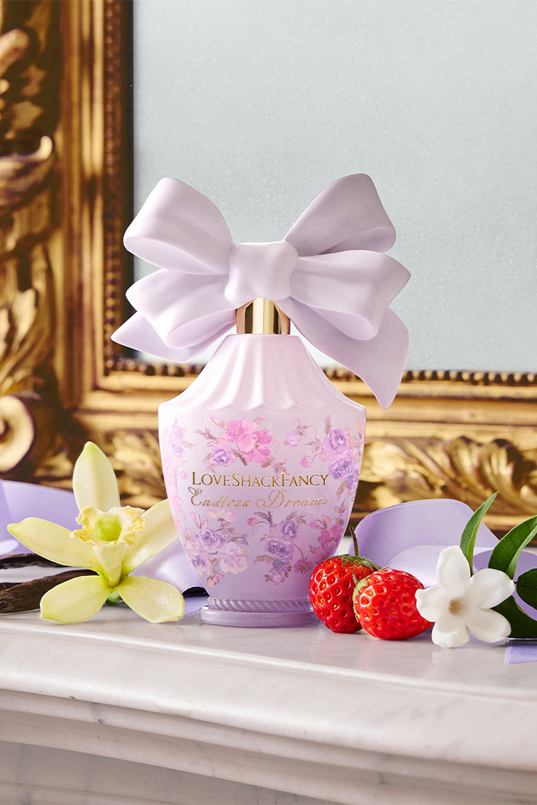 Pink floral eau de parfum bottle with oversized satin bow and decorative label