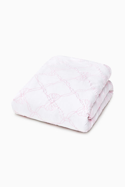 Folded embroidered duvet cover with pink-toned outline pattern and smooth finish