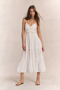 White cotton midi dress with spaghetti straps, embroidered panels, and tiered skirt