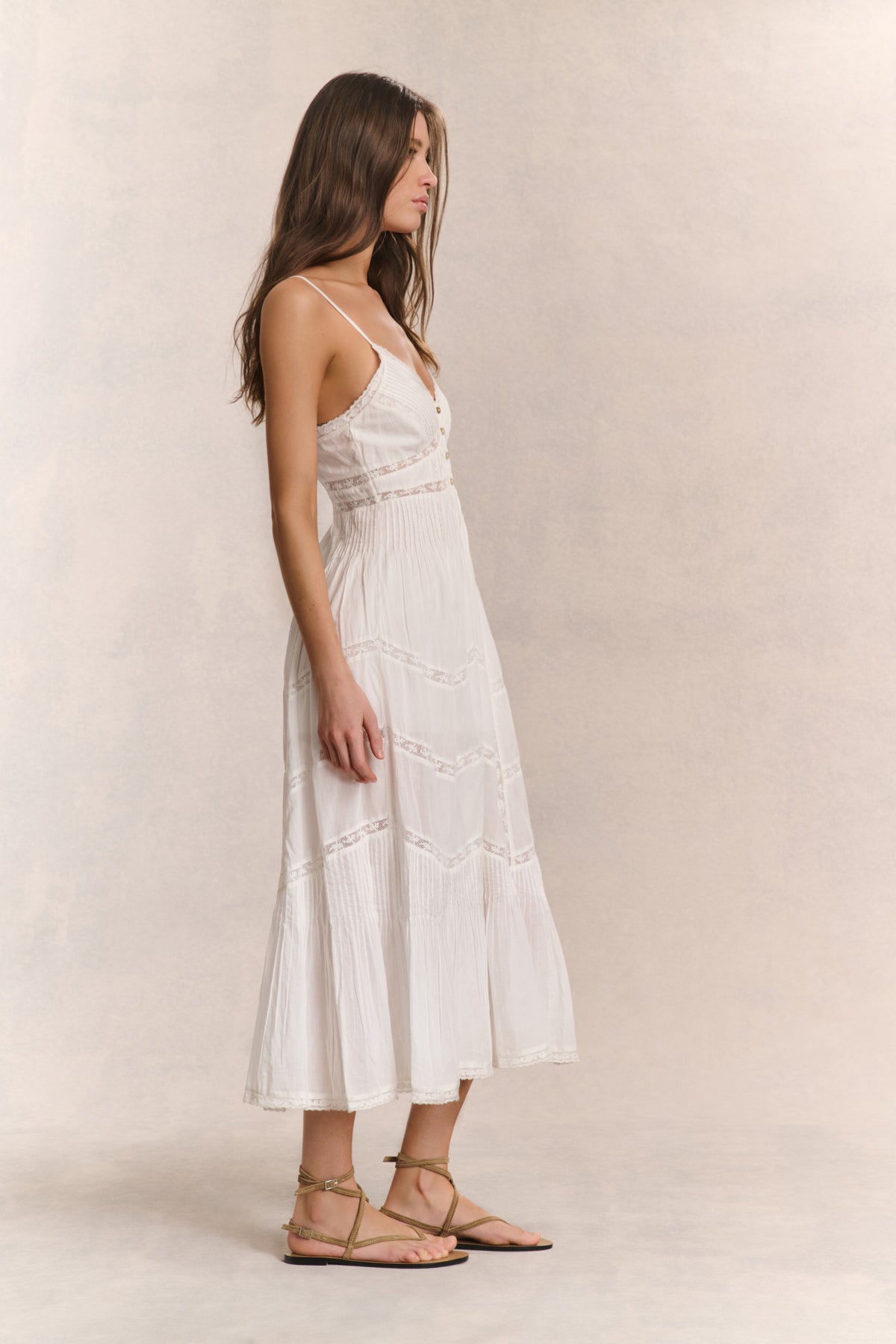 White cotton midi dress with spaghetti straps and tiered patchwork skirt, side view