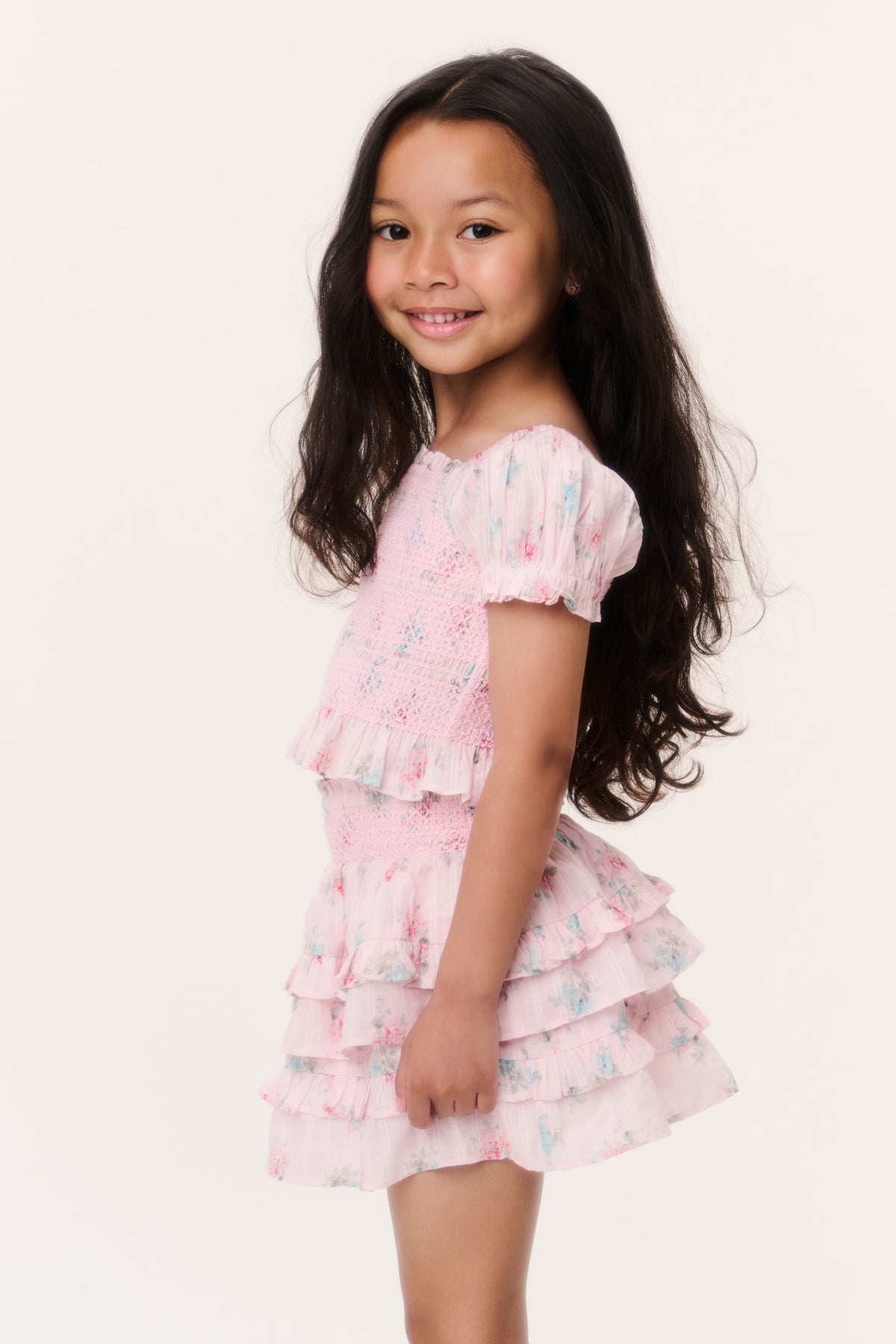 Girls pink ruffle top with puff sleeves and tiered ruffle hem, side view