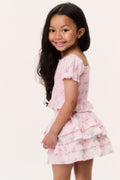 Girls pink puff-sleeve ruffle top with tiered hem, angled view