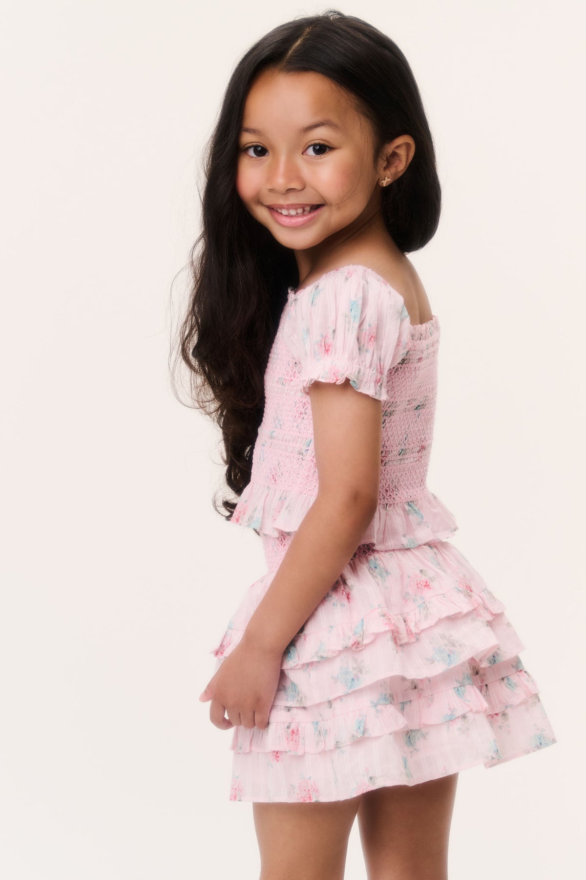 Girls pink puff-sleeve ruffle top with tiered hem, angled view