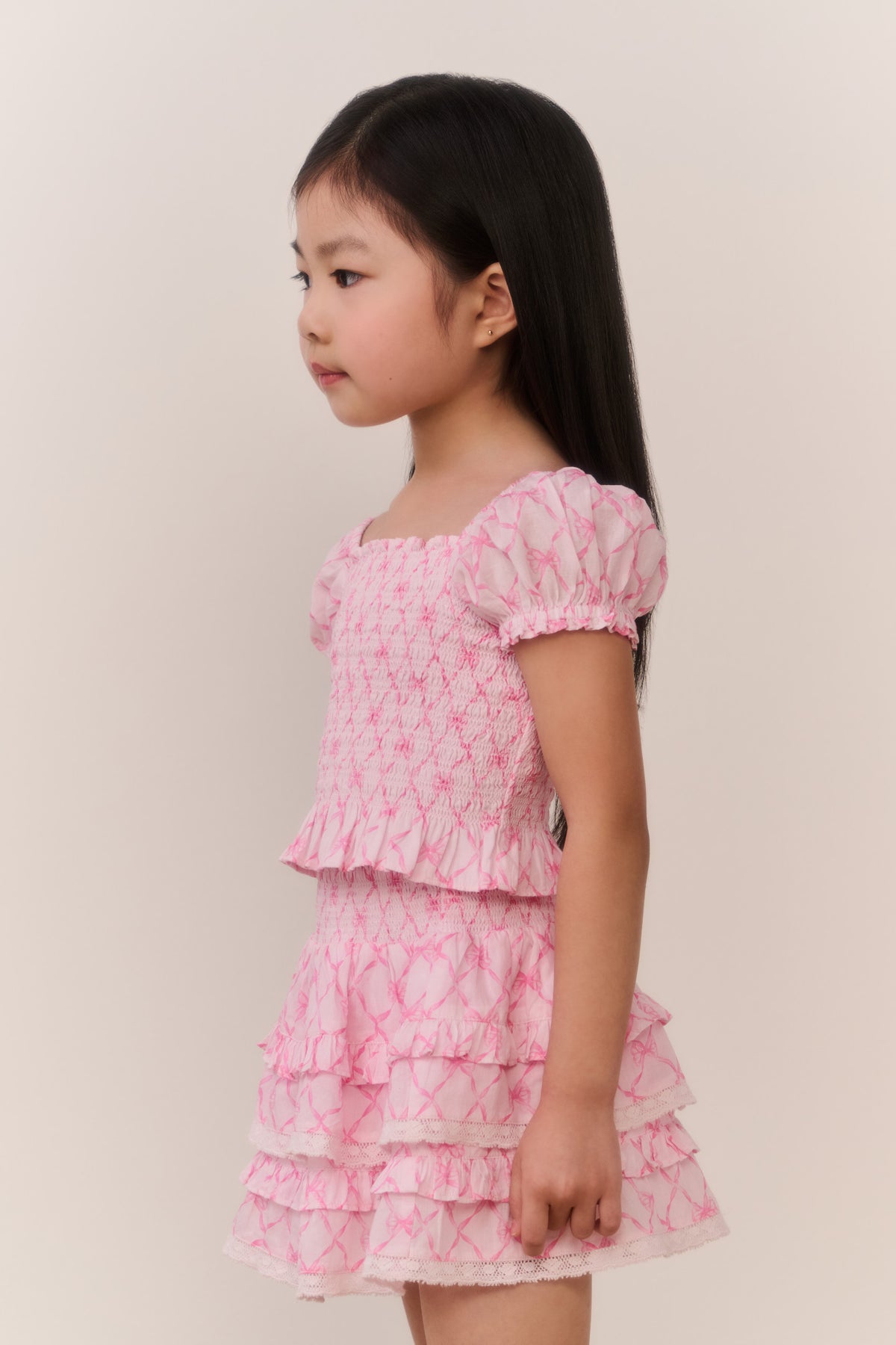 Girls pink tiered mini dress with ruffled layers and short puff sleeves
