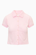 Pink polo shirt flat lay with button placket and short sleeves