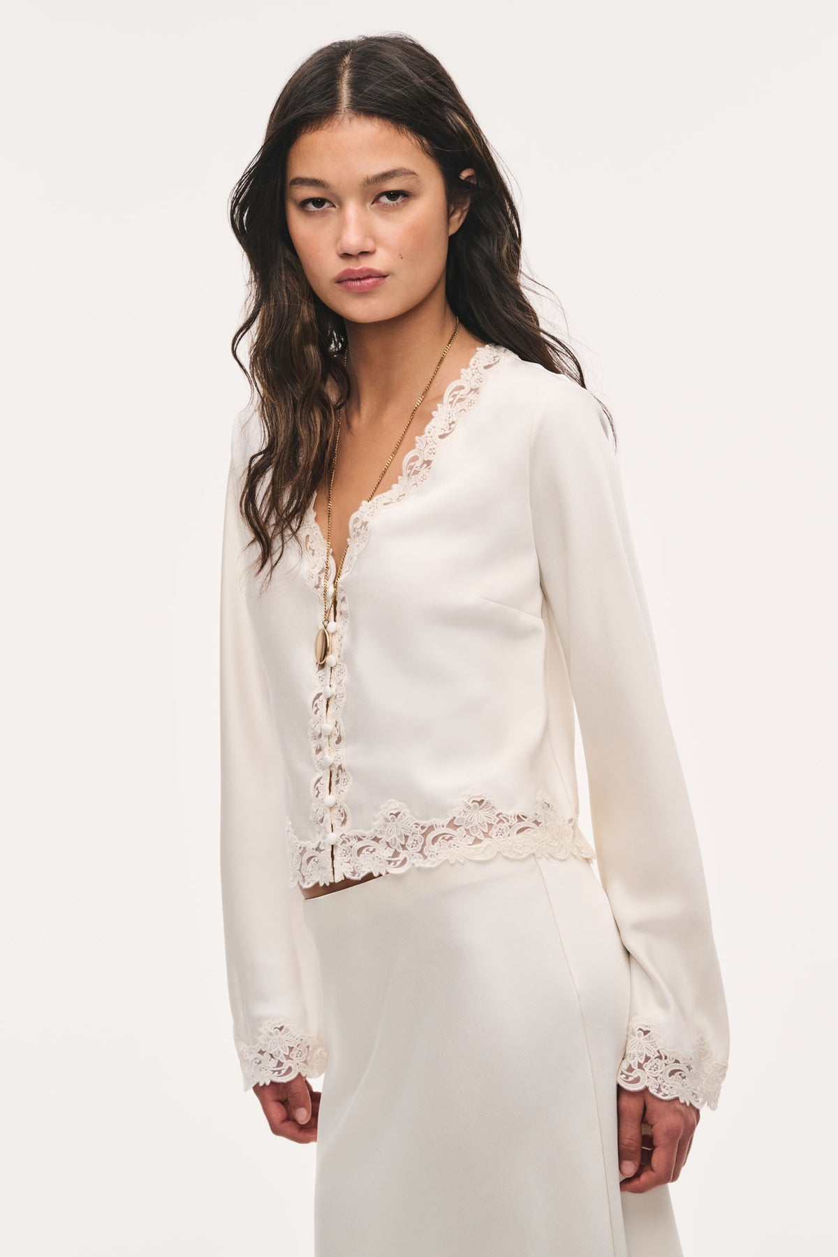 Cream crepe top with V-neck, button-front placket, and scalloped lace trim