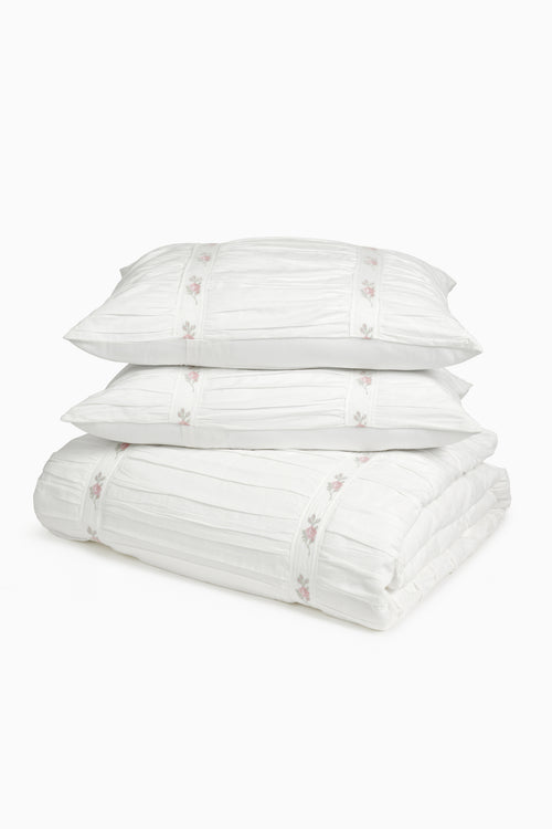 White embroidered duvet cover and sham set with small pink floral accents