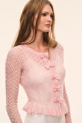 Light pink pointelle cardigan with bow-front trim and layered ruffle hem, long sleeves