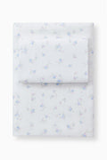 Light blue bow printed sheet set with pillowcases, folded stack on a base