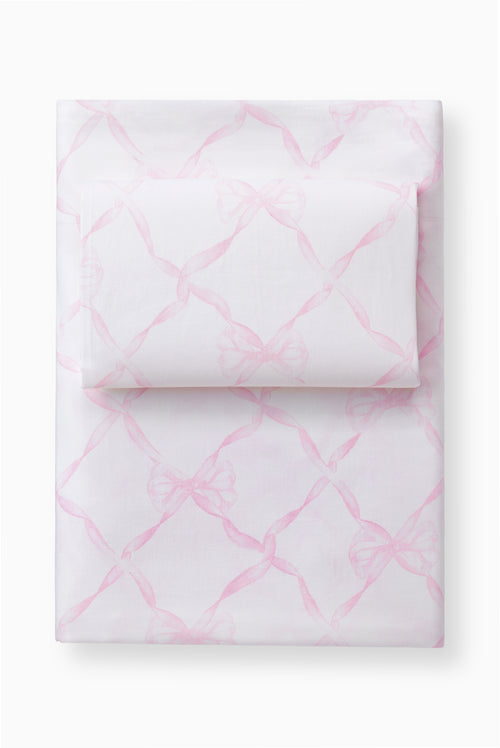 Light pink bow printed sheet set with pillowcases, folded stack on a base