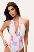 Halter one-piece swimsuit with plunging V-neck, patchwork print in white, blue, and pink.