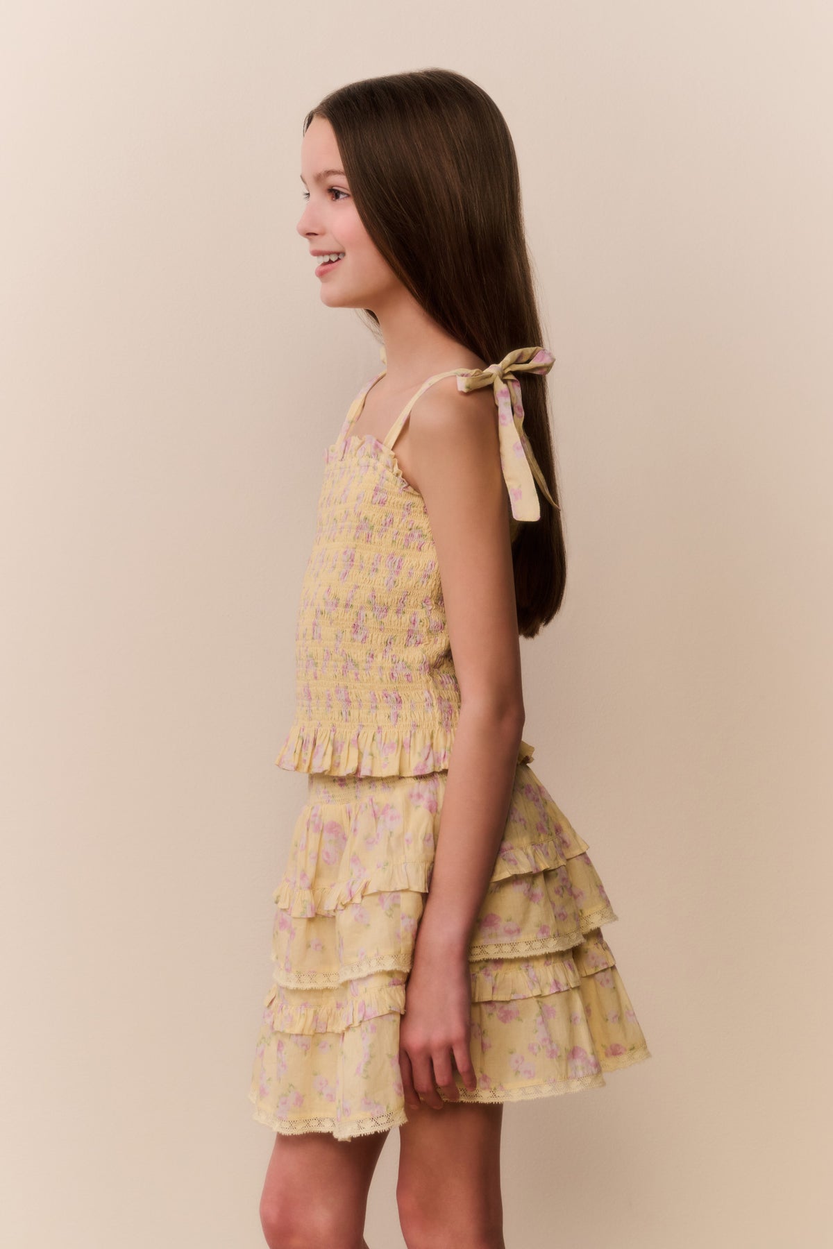 Tween floral top with bow tie straps and tiered ruffle skirt hem, side view